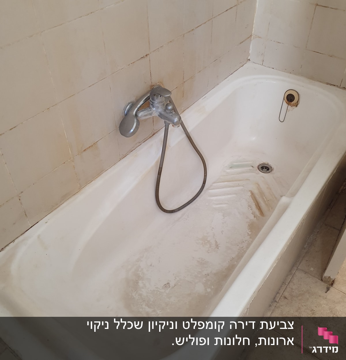 אמבטיה מלוכלכת עם כתמים, ברז ומקלחת יד